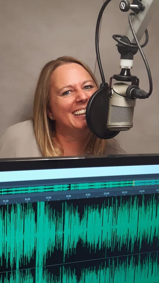 Nicole Gansner lachend am Mikrofon im Studio von Drift FM